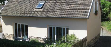 Ein kleines, eingeschossiges Haus mit einem Ziegeldach, einem kleinen Fenster und einer Tür.