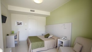 A bedroom with a bed, a desk, a chair, a bedside table, and a TV. - Hotel Valeria del Mar (Belvedere Marittimo)