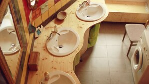A bathroom with two sinks, a mirror, and a washing machine. - Spirit Lodge Leipzig - Hostel (Leipzig)