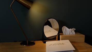 Uma mesa com um livro intitulado 'Gucci Book', uma caixa de lenços e uma luminária.