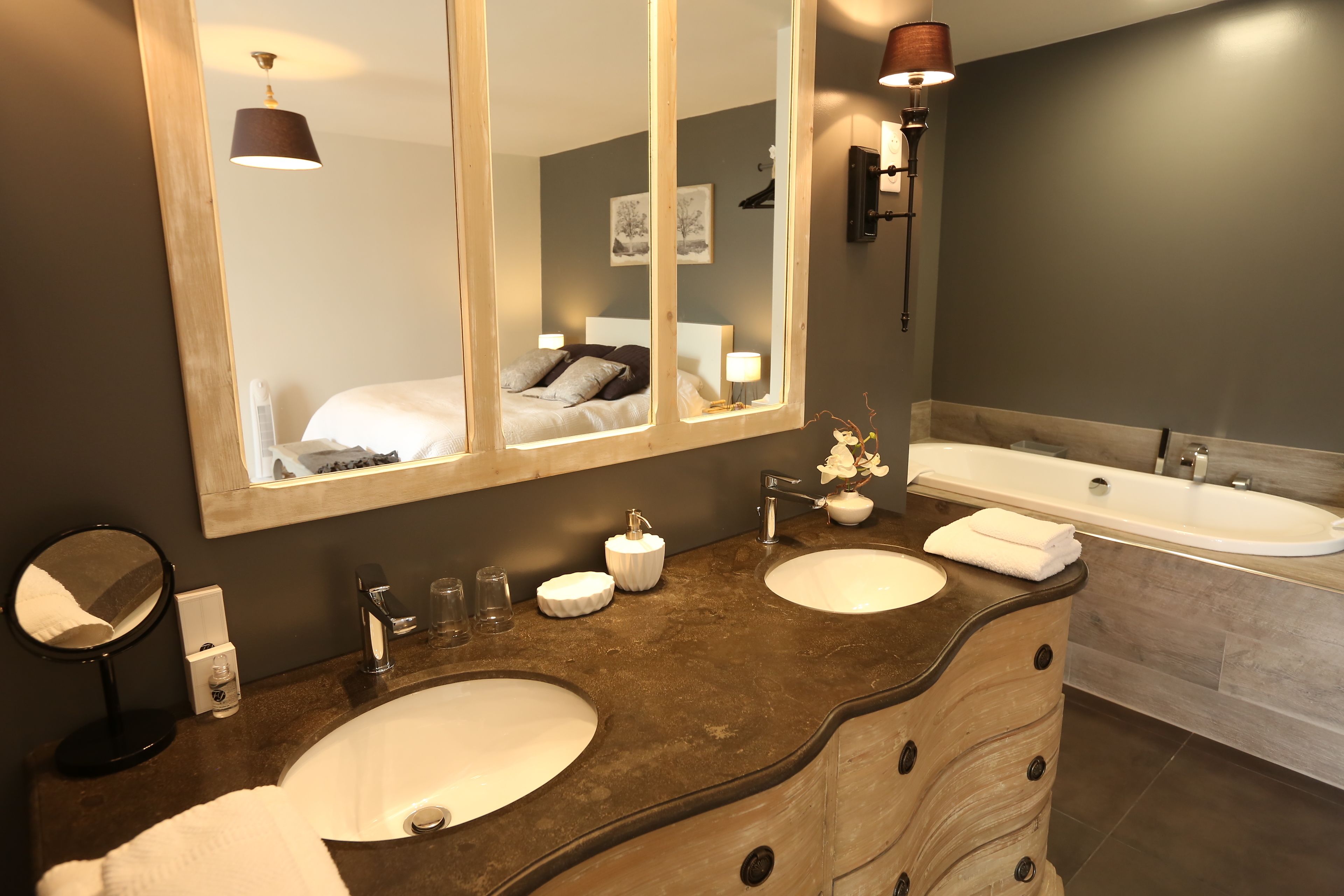 Un baño moderno con dos lavamanos, un espejo grande y una bañera.
