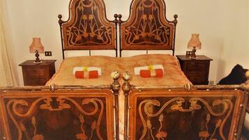 Un letto con una testiera e un piedeletto elaborati, affiancati da due comodini con lampade.