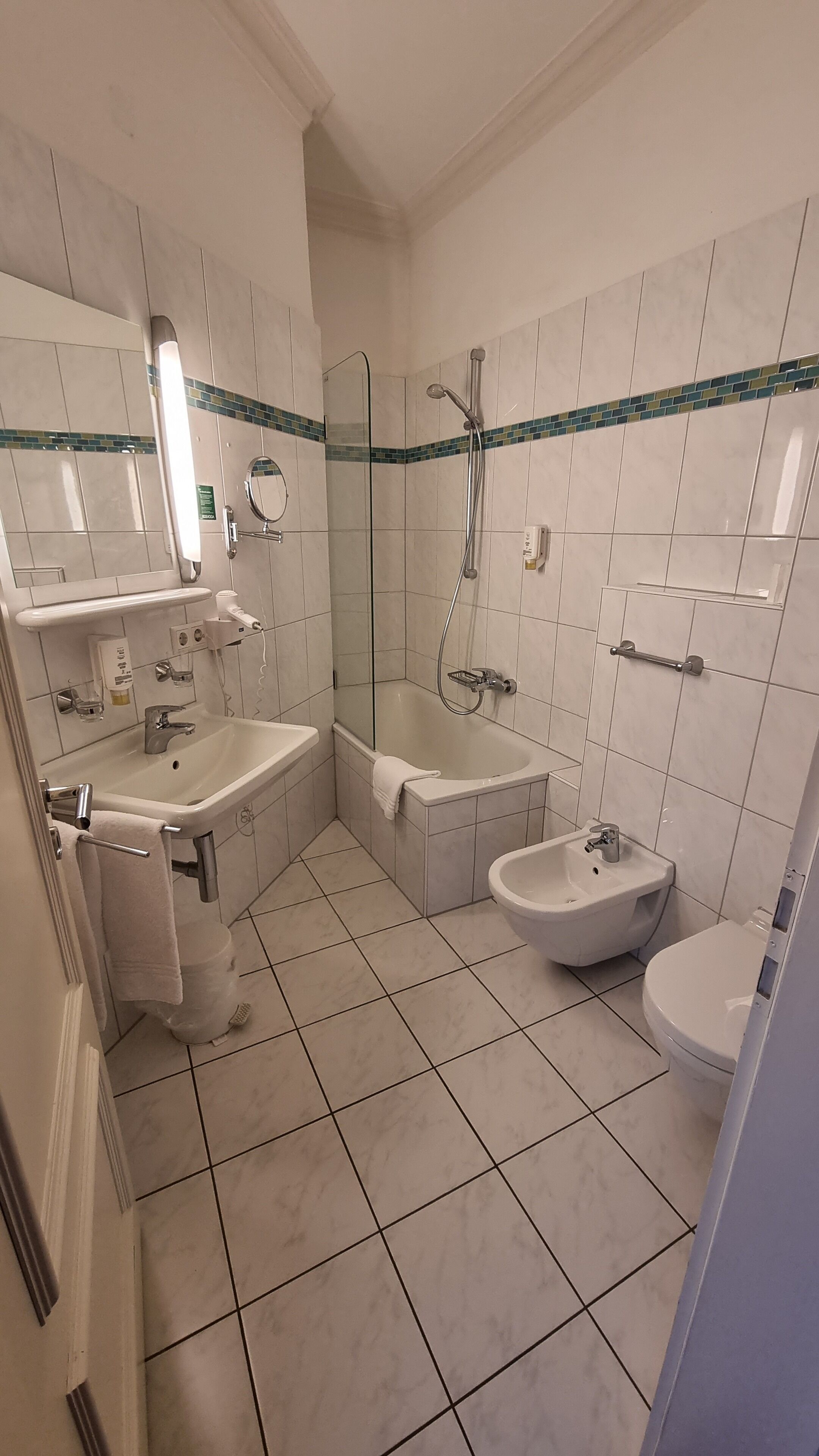 Une salle de bain équipée d’un lavabo, de toilettes, d’un bidet et d’une baignoire.