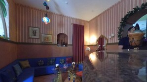 A living room with a blue sofa, a glass coffee table, and a decorative mirror. - Caterina House (San Lucido)