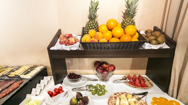 Une table de buffet proposant une variété de fruits, de légumes et de viandes.
