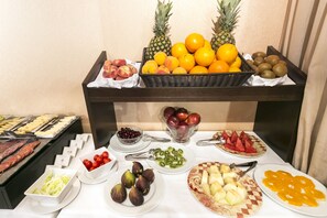 Una mesa de buffet con diversas frutas, verduras y carnes.