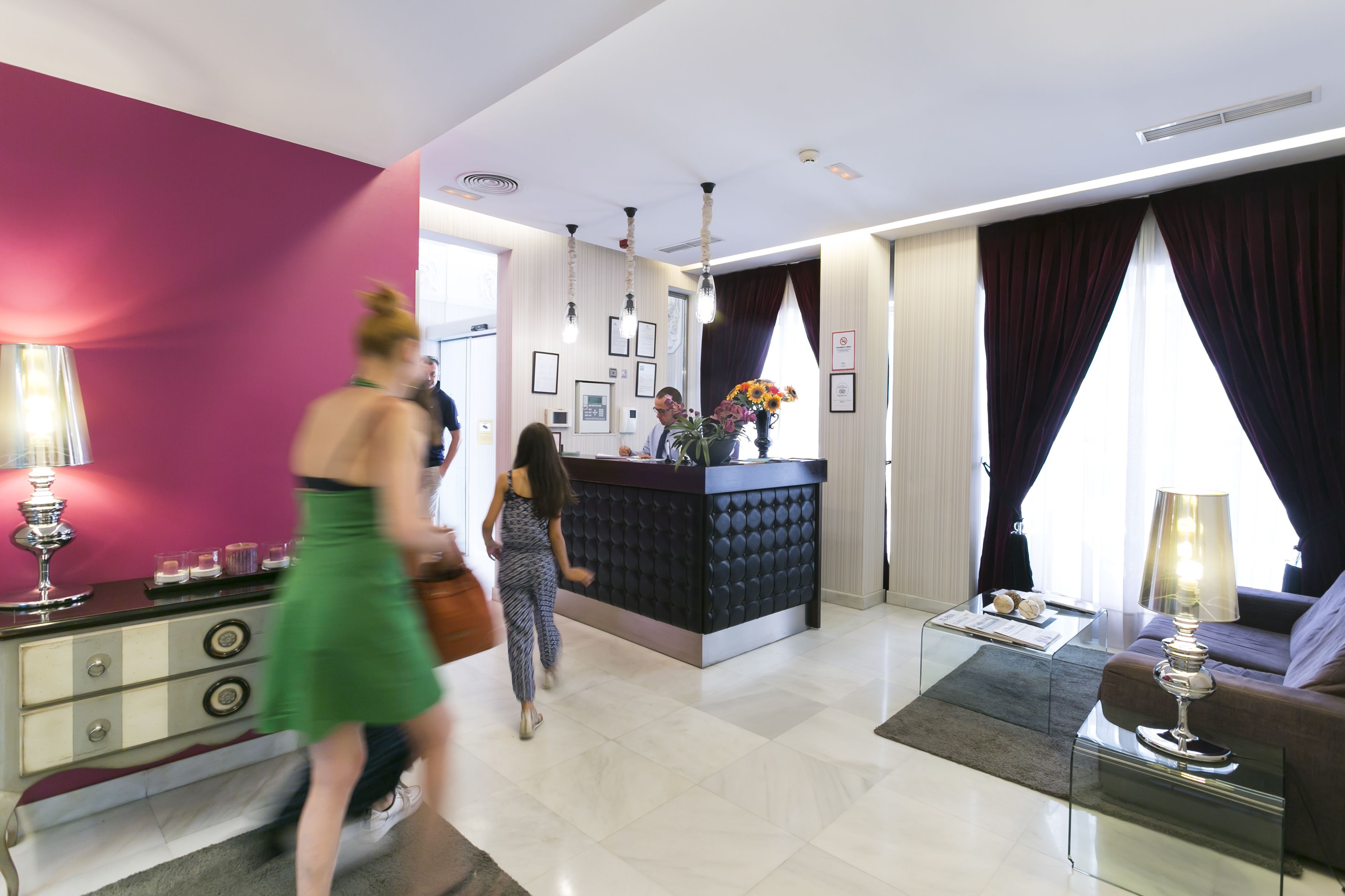 A modern hotel lobby with a reception desk, a sofa, and a coffee table.