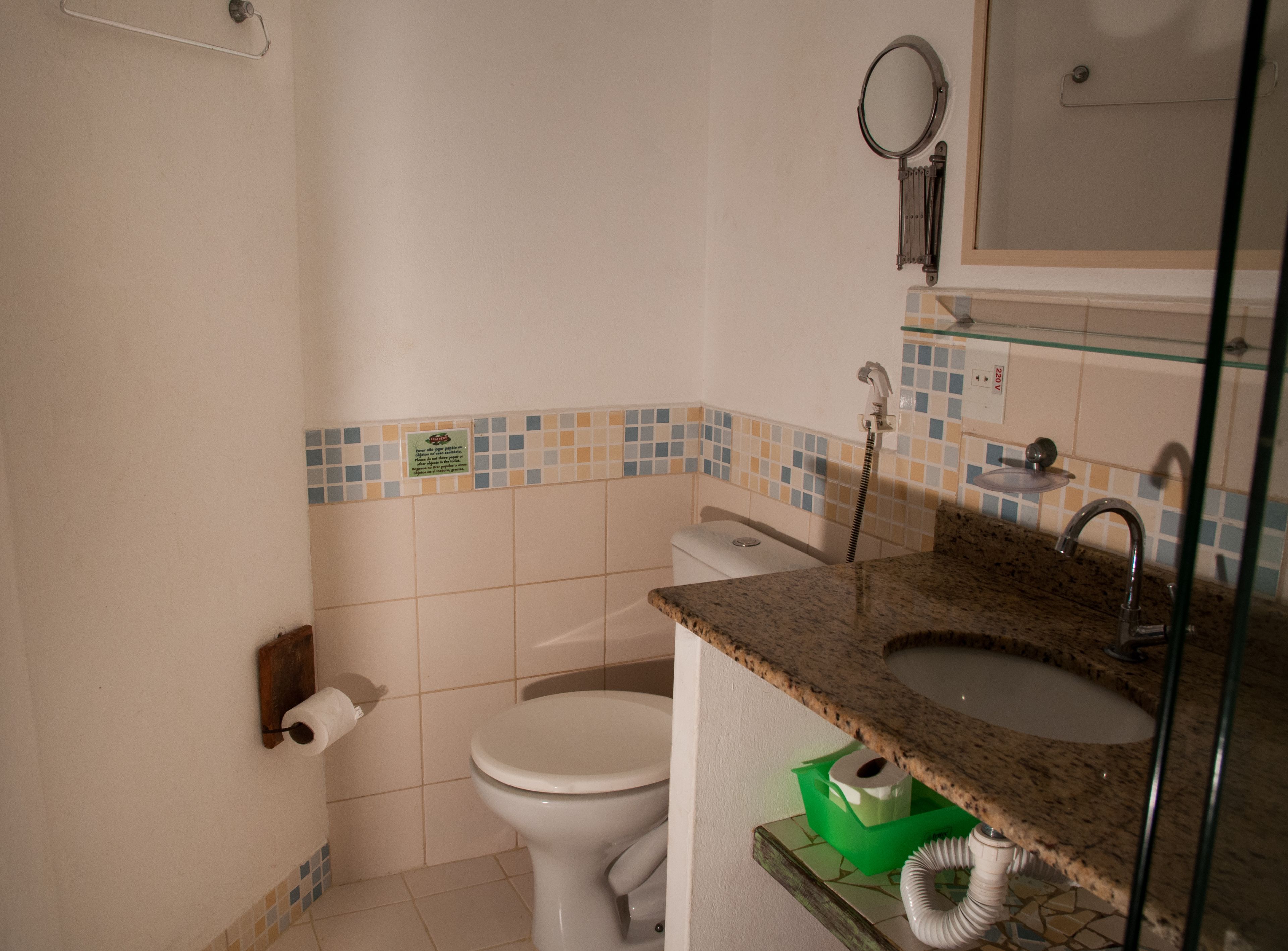 A bathroom with a toilet, sink, and shower.