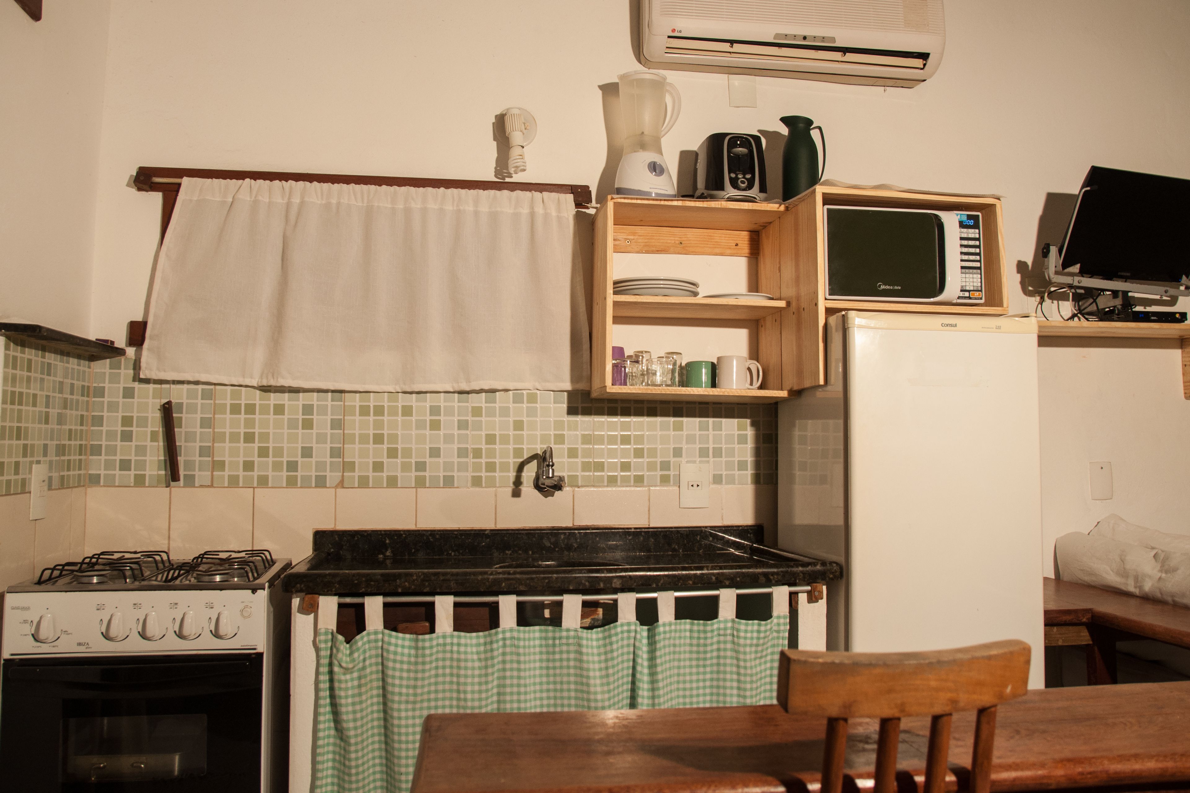 A compact kitchen with a gas stove, a microwave, and a refrigerator.