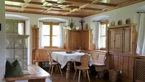 Un comedor tradicional con muebles de madera, una mesa cubierta con mantel blanco y un banco.