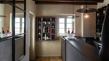 A modern kitchen with dark cabinetry, a wine rack, and pendant lighting.