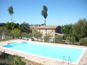 Una piscina al aire libre, sillones reclinables de piscina
