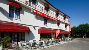 Ein Hotel mit Außenbestuhlung und einer roten Markise.