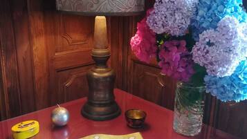 Ein Tisch mit einer Lampe, einem Blumenstrauß, einer kleinen Kerze und einer dekorativen Schachtel.