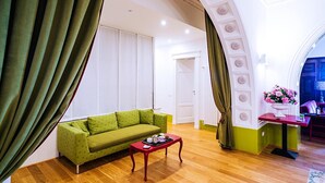 A living room with a green sofa, a red coffee table, and a white door.