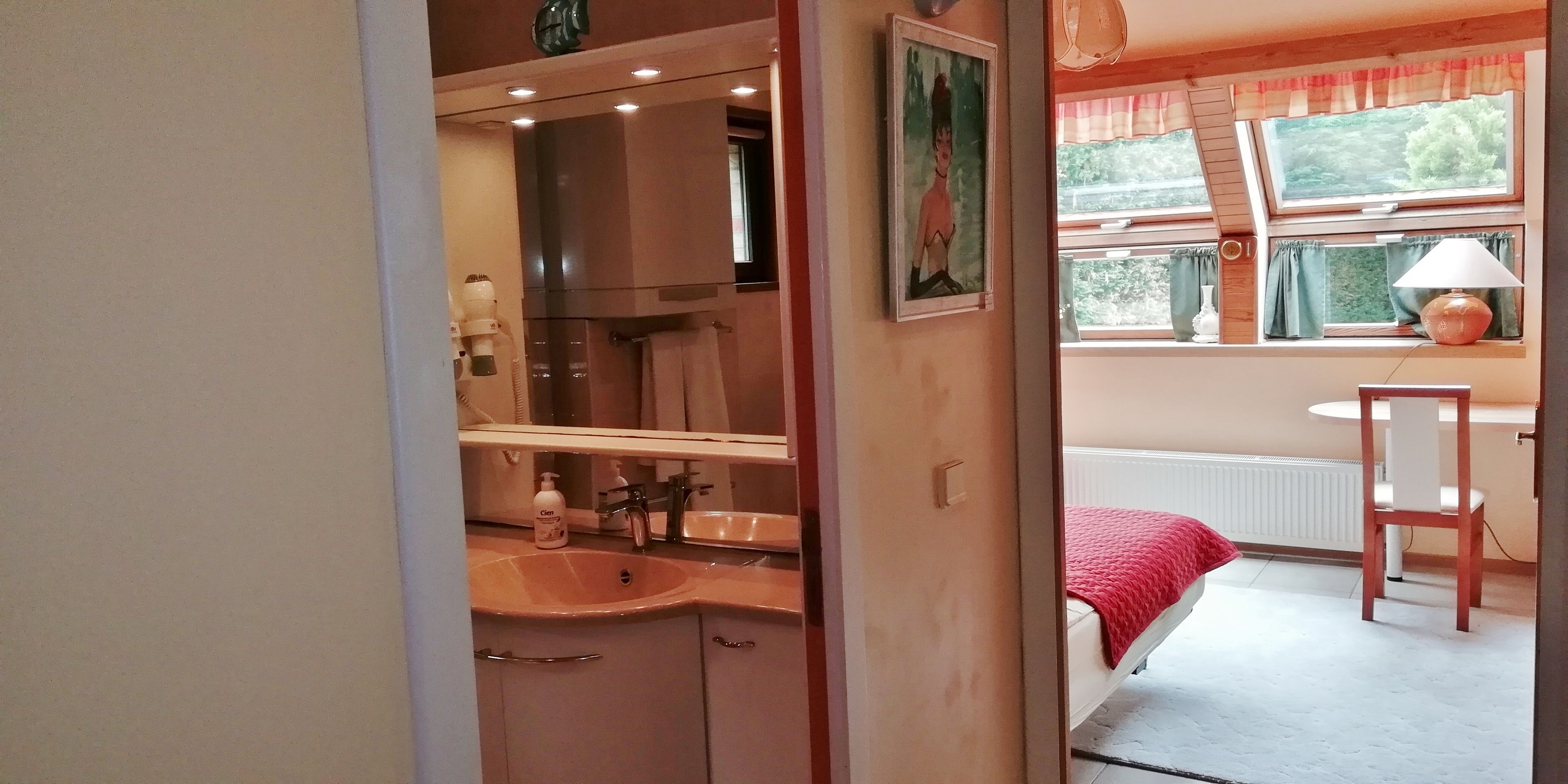 Un bagno con lavandino, specchio e portasciugamani.