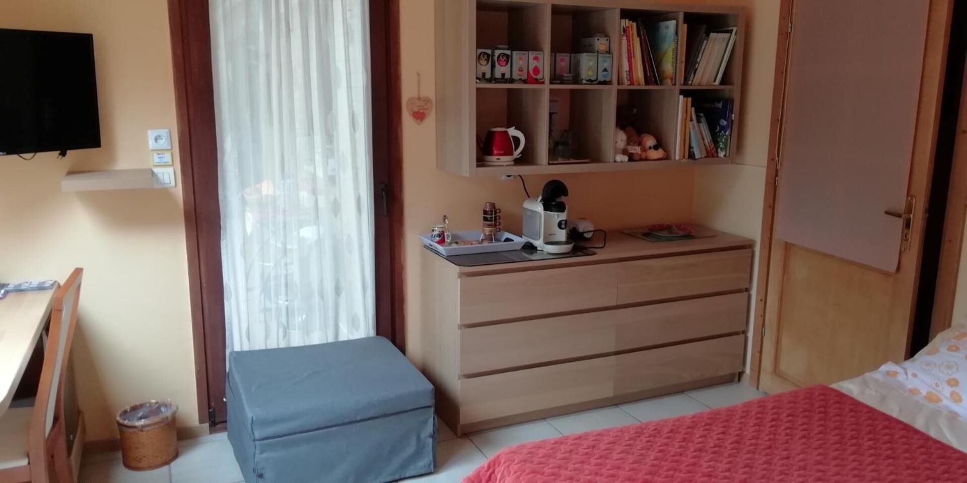 Un dormitorio con cama, escritorio, estantería y armario.