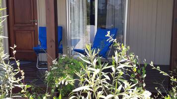 A wooden door, a blue chair, and a glass door with a curtain.