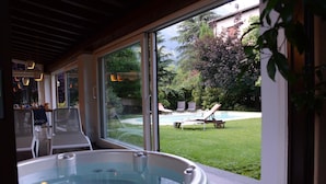 Tinaco en un área exterior cubierta con vista a un patio trasero que tiene piscina y sillas de descanso.