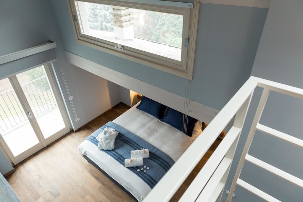 A bedroom with a bed, a window, and a view of the outdoors.