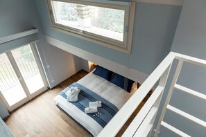 Un dormitorio con cama, ventana y vistas al exterior.