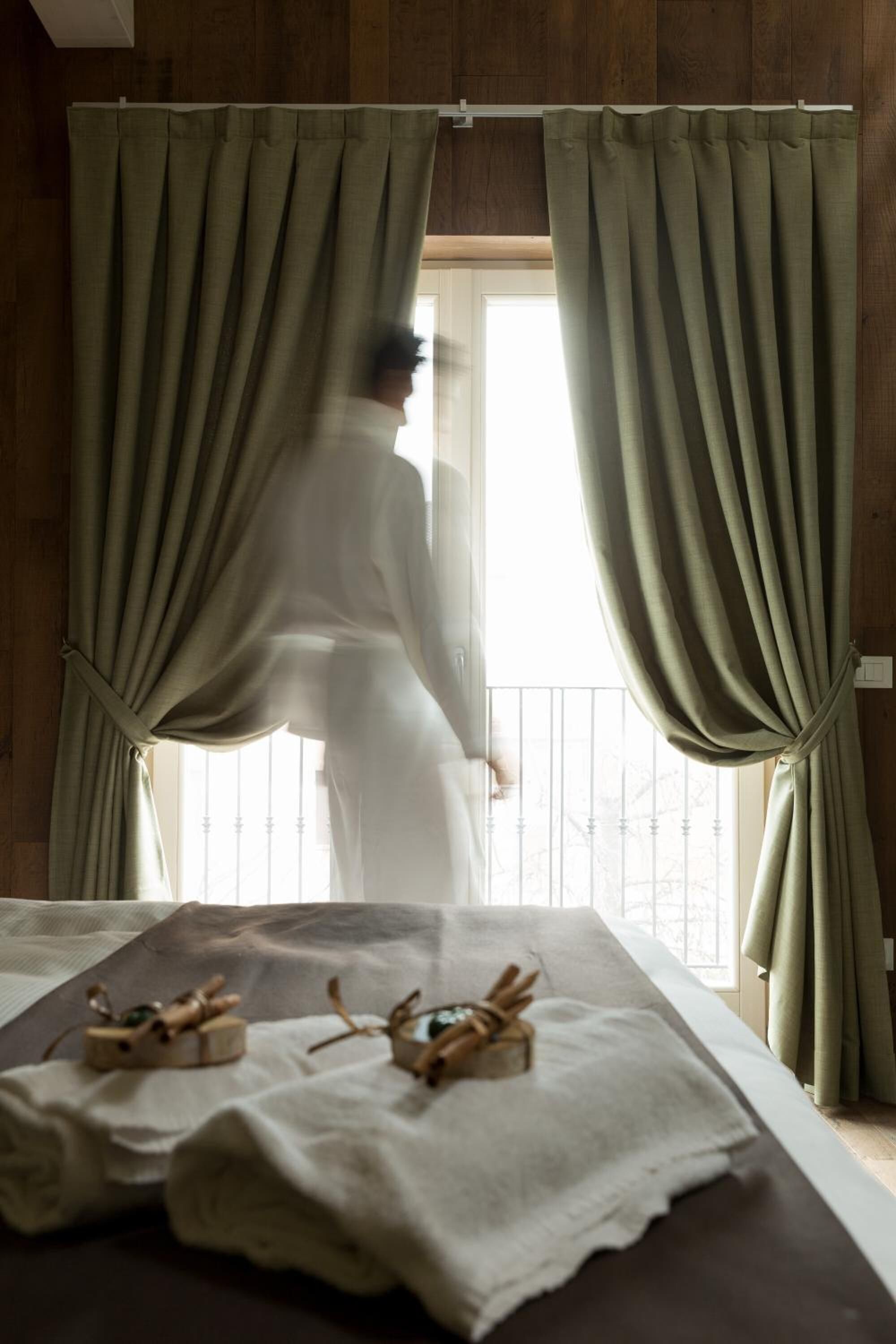 Une pièce avec un lit, des rideaux et une fenêtre.
