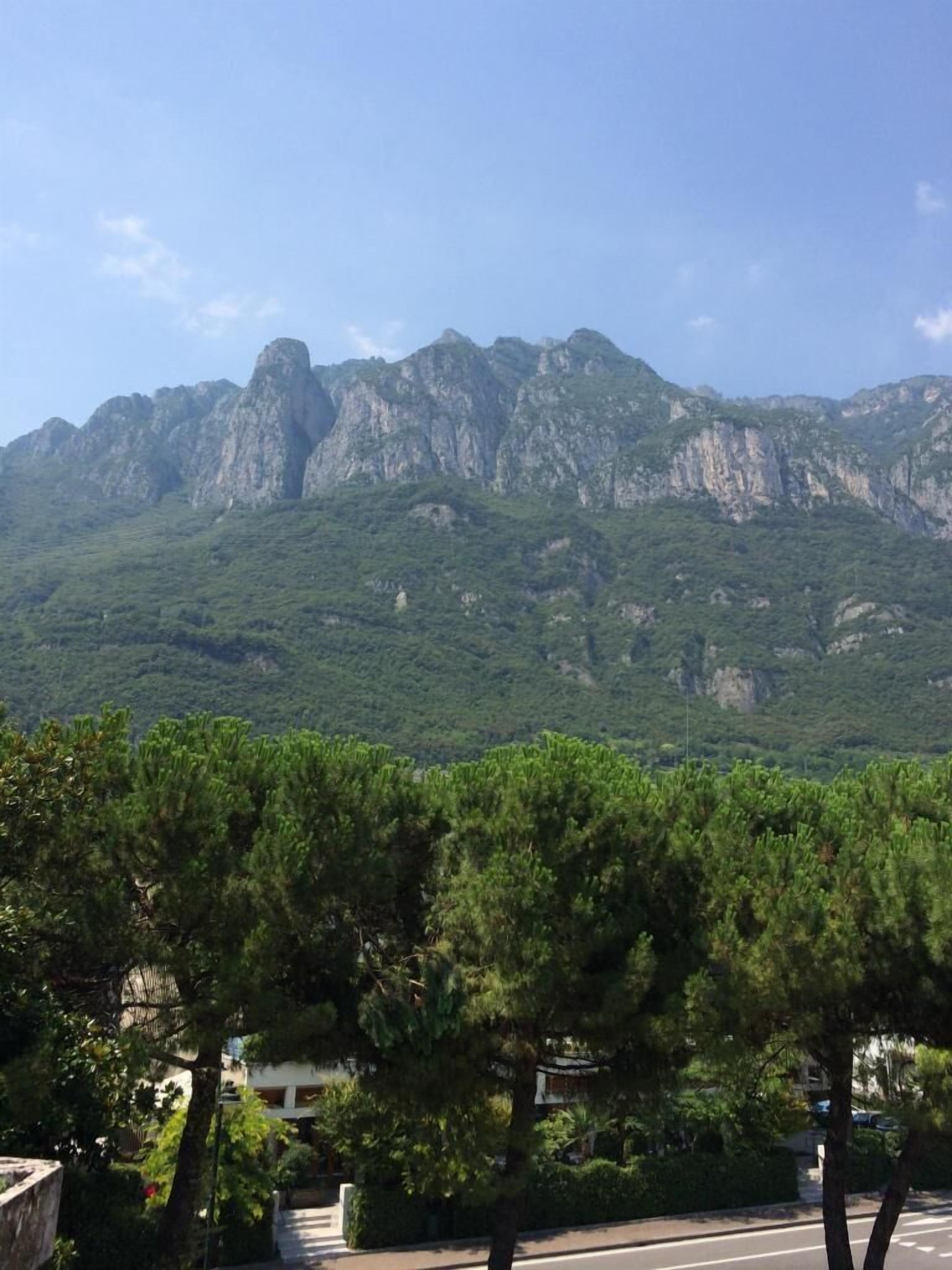 A mountainous landscape with dense green vegetation and a clear sky.