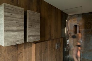 Un baño moderno con paneles de madera y una cabina de ducha de vidrio.