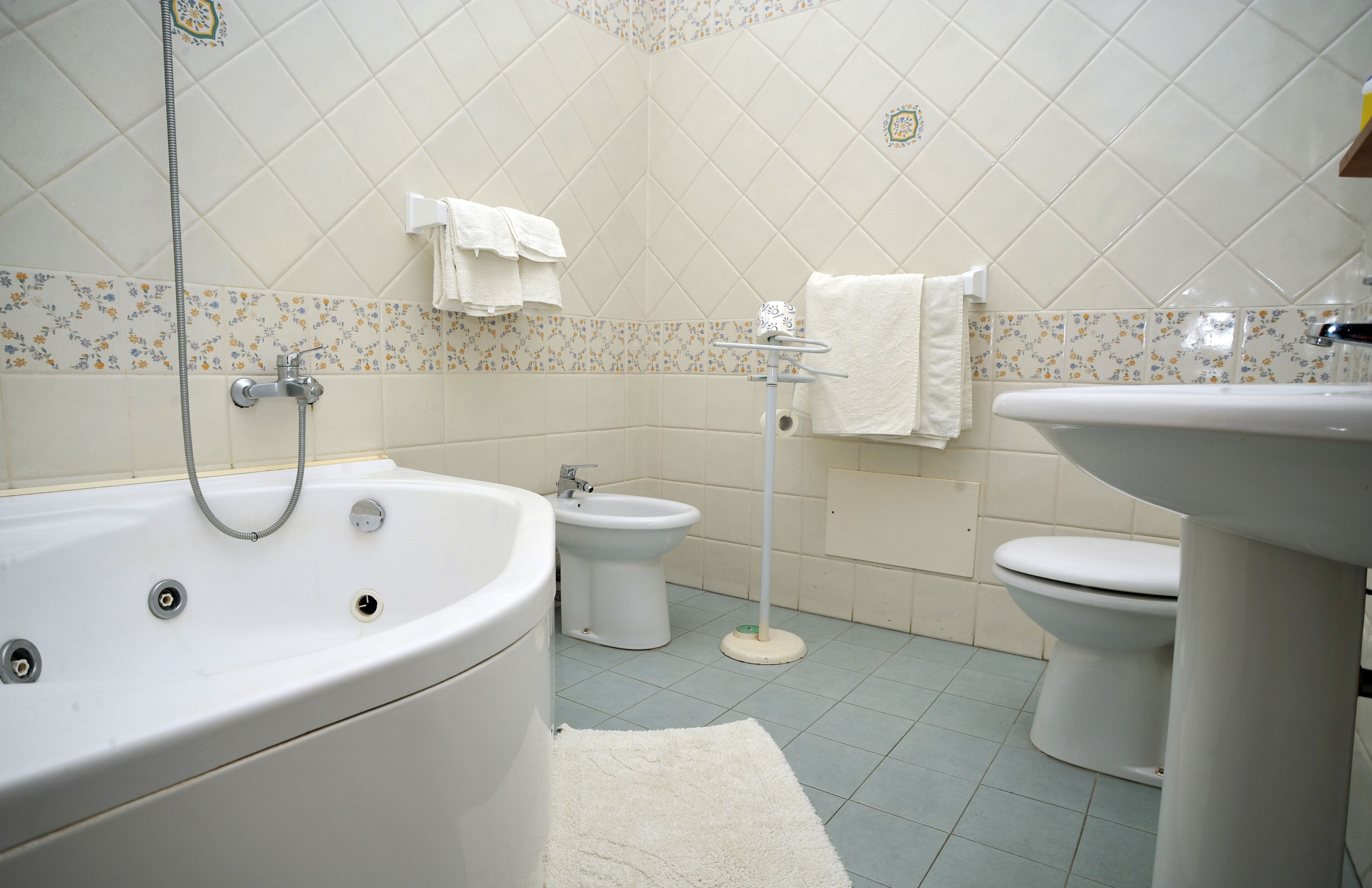 Un baño con bañera, bidé e inodoro.