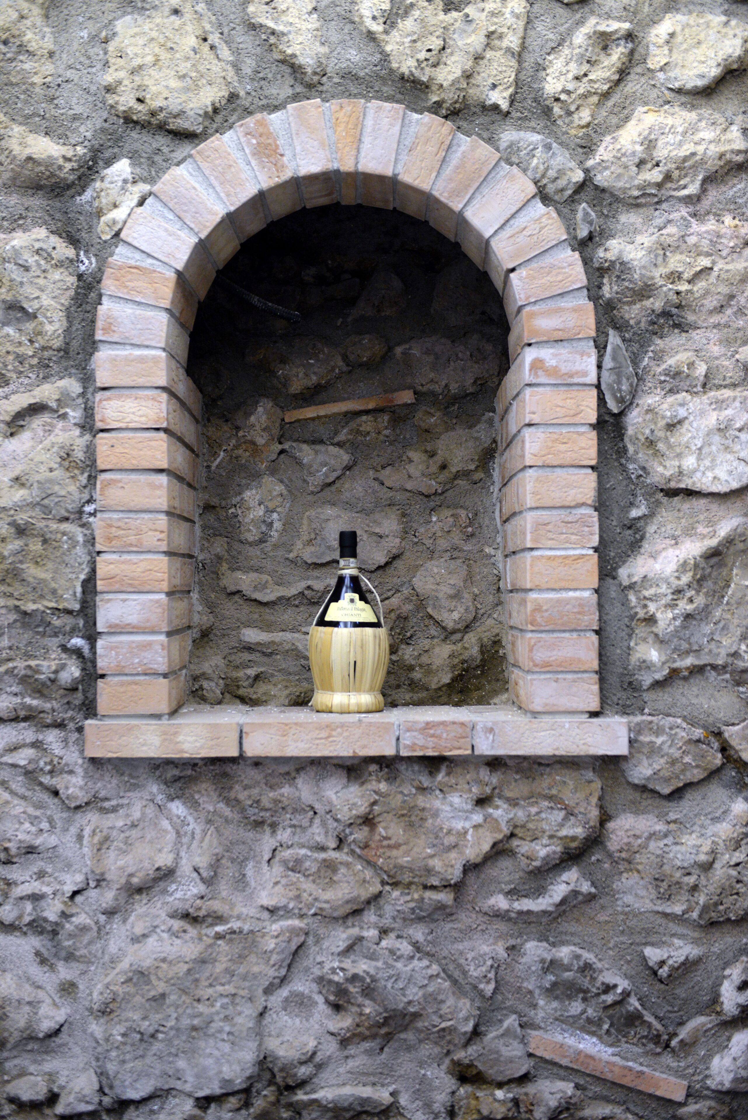 Eine Steinsäule mit einem Ziegelbogen und einer Flasche in der Mitte.