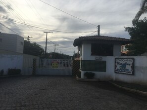 Zona residencial cerrada con un letrero que indica 'CONDOMÍNIO Viveras do Atlântico'.