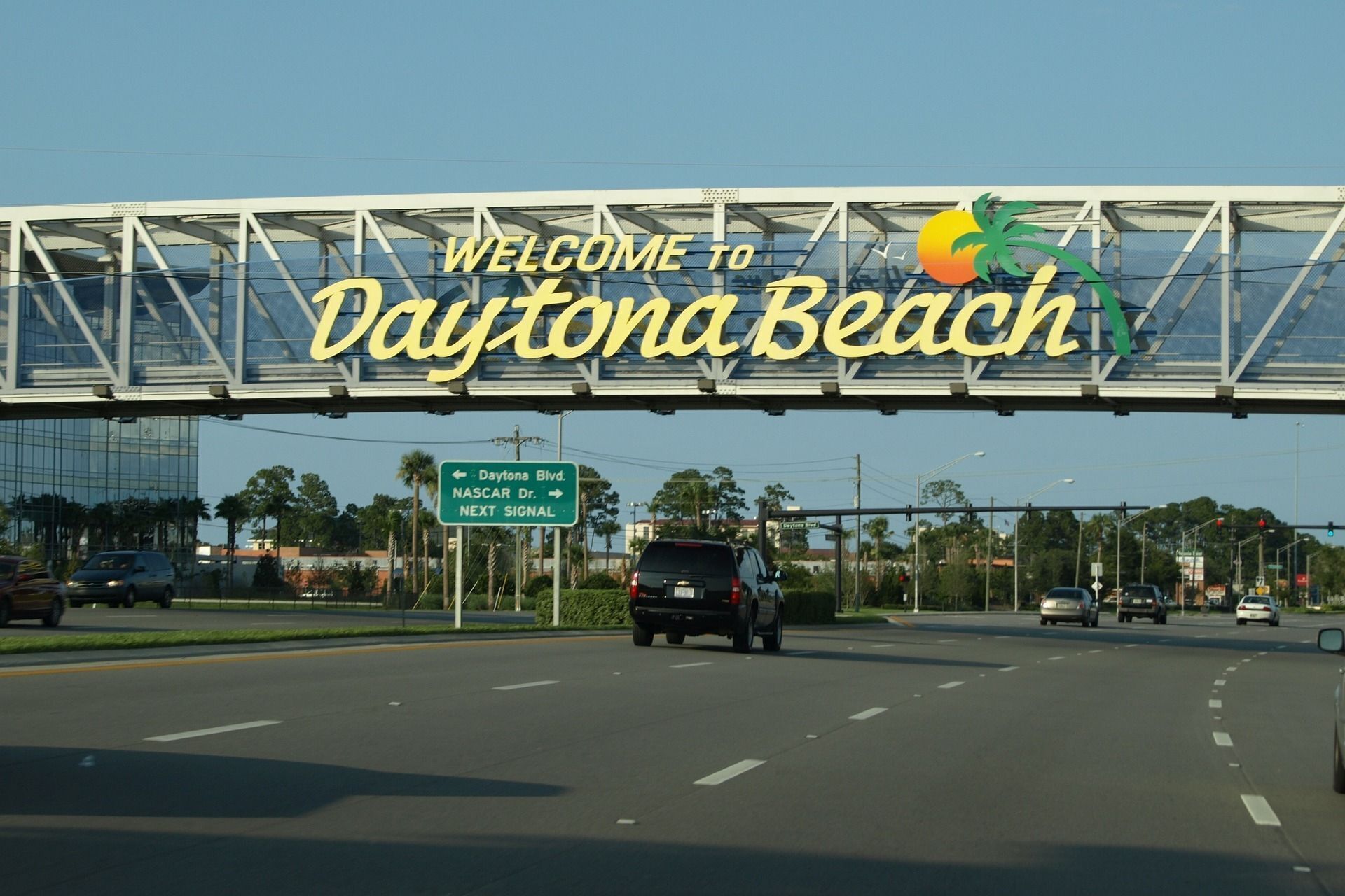 A road sign with 'Welcome to Daytona Beach' and directional signs for Daytona Blvd. and NASCAR Dr.
