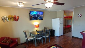 A compact living space with a dining area, kitchenette, and a ceiling fan.