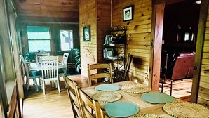 A wooden dining area with a table set for four, surrounded by chairs.