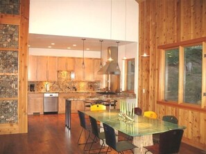 Enjoy meals in this kitchen with a large island, sink, and stove, and dine at the adjacent table with chairs.