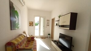 A living room with a sofa, a television, and a cabinet. -  Full comfort cottage a few steps from the sea and from the center (porto cesareo)