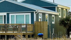 A two-story house with a covered porch and a garage. - 9/19-26 WOW SALE! Oceanfront House, 4-7 Night Stay, WEEKLY DEAL, Walk to Pier! (Kure Beach)