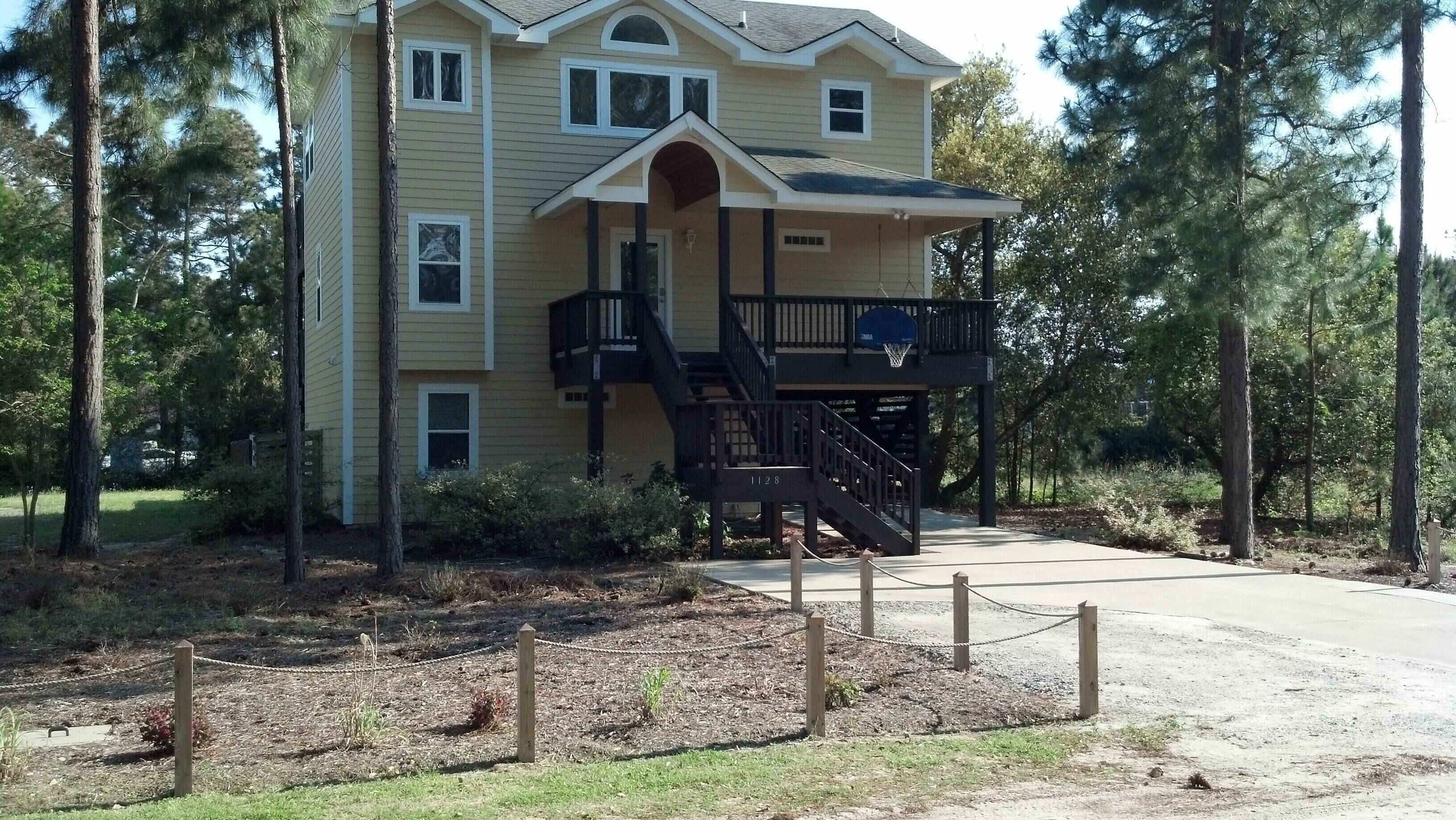 A two-story building with a balcony and a basketball hoop.