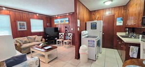 A compact living space with a sofa, coffee table, TV, and kitchenette.
