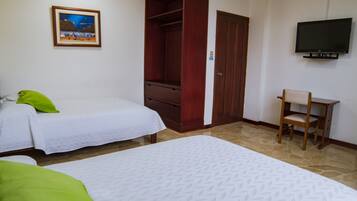 Una camera d'albergo con due letti, un armadio in legno, una televisione e un quadro appeso al muro.