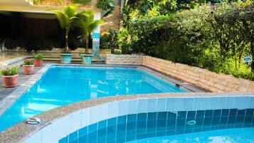 Una piscina al aire libre, tumbonas