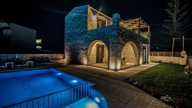 A modern building with a stone facade, a swimming pool, and a well-maintained lawn. - Villa Katerina (Chania)