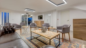 Una sala de estar moderna con sofás de cuero, una mesa de centro con un cuenco decorativo y una alfombra estampada.