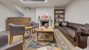 Una sala de estar moderna con chimenea, un sofá, una mesa de centro y una estantería.