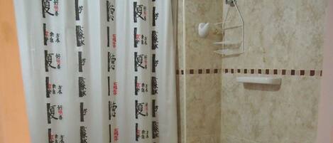 A bathroom with two toilets, a sink, and a shower curtain with Japanese characters.