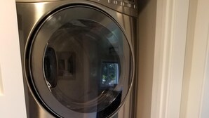Una lavadora y secadora apiladas en un rincón de la habitación.
