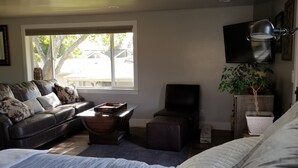 Una sala de estar con un sofá, una mesa de centro, un televisor y una planta.
