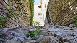 A narrow stone pathway flanked by stone walls with a building in the background. - Villa Fragola beautiful house whit pool and panoramic view (Motovun)