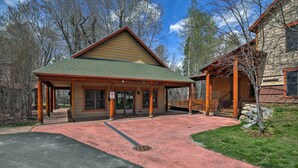 A lodge with a covered entrance, a stone building to the right, and a paved driveway. - Cozy Driggs Condo w/ Hot Tub & Ski Shuttle Service (Driggs)
