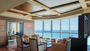 A spacious living room with a large window overlooking the sea, wooden ceiling beams, and a modern interior design. - Setai (Miami Beach)